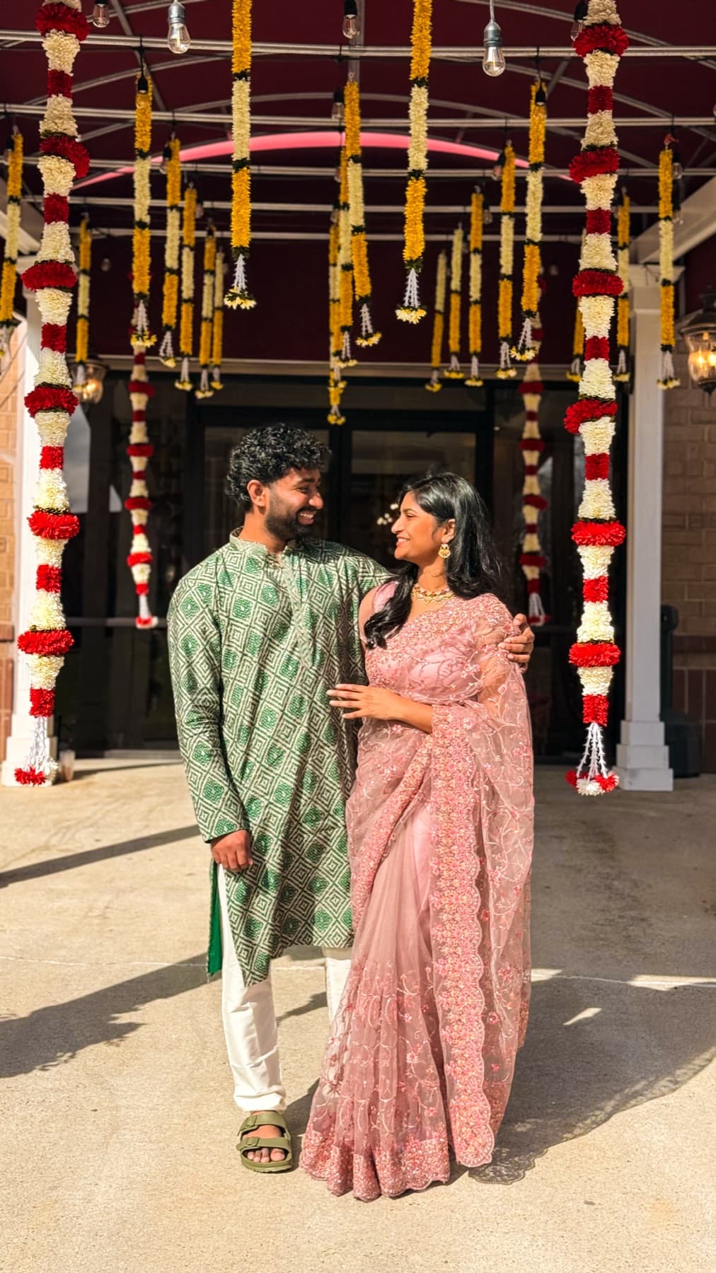 Tejesh & Madhu Padisetti under traditional flower garlands